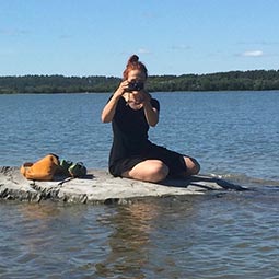 Ilse Hotz treibt auf Floß im Wasser und fotografiert dabei